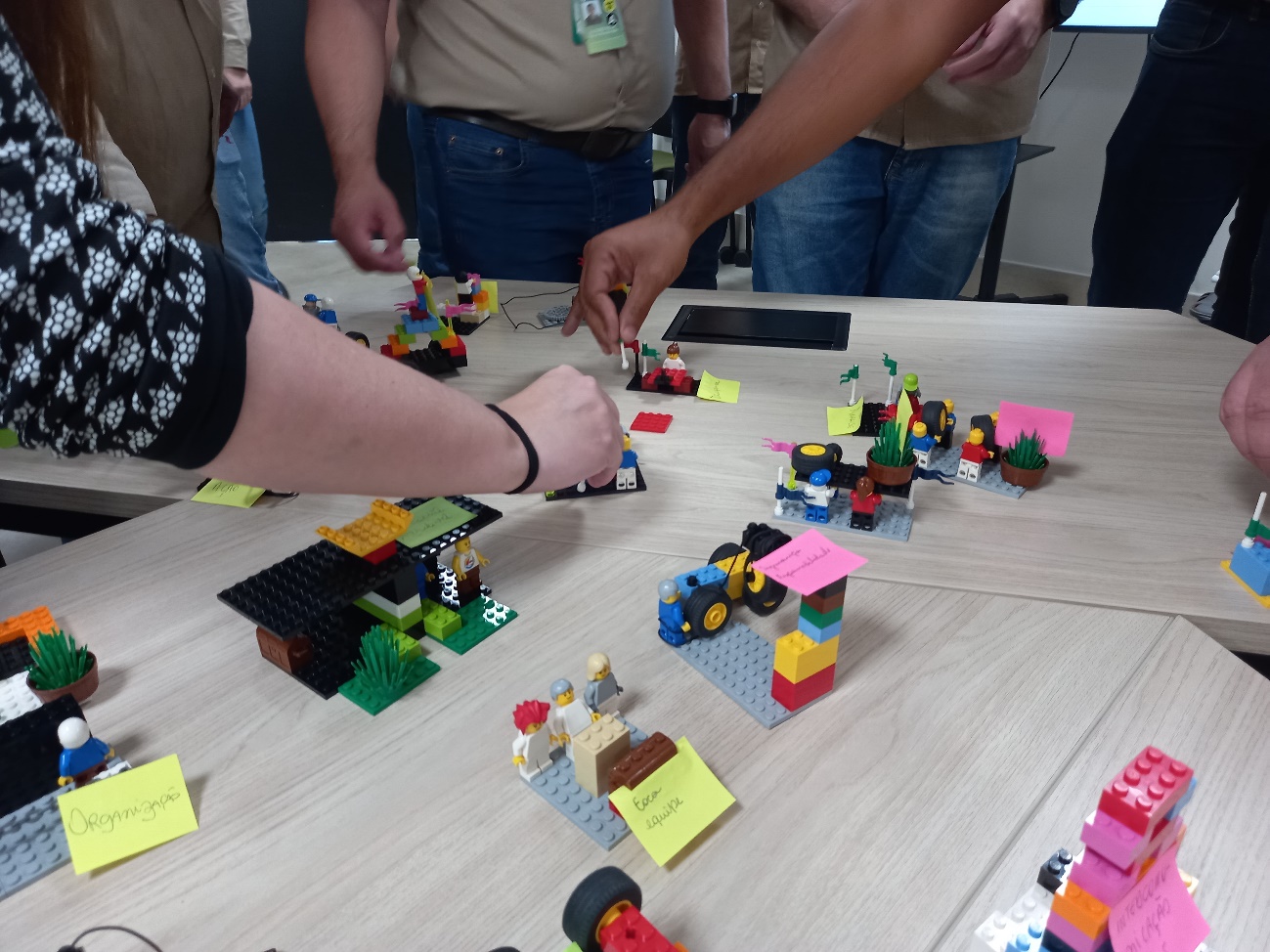 Participantes construindo modelos com peças Lego® durante uma experiência facilitada